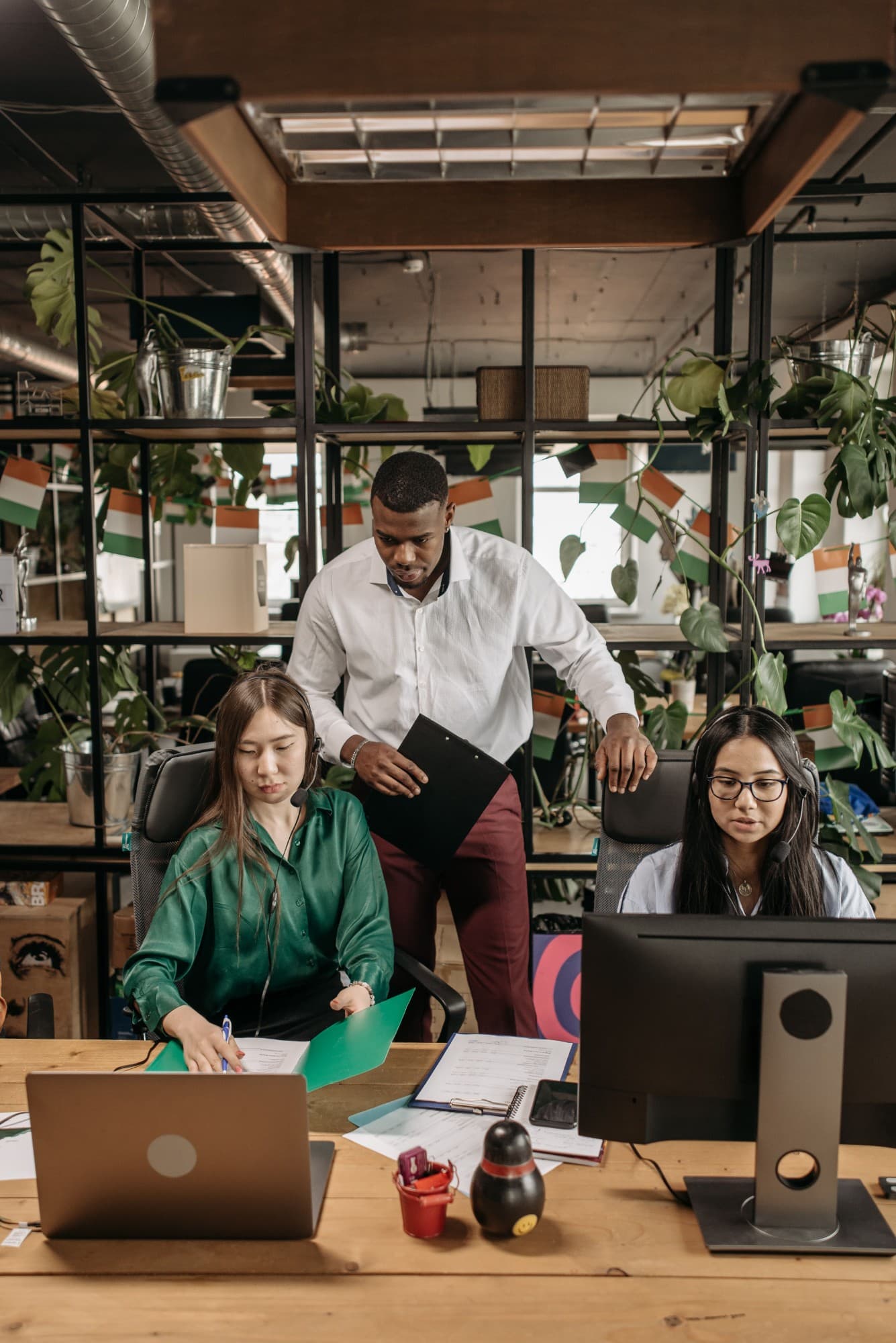 Team im Büro bei der Arbeit am Schreibtisch, symbolisch für die eigene Arbeitskraft als Einkommensquelle